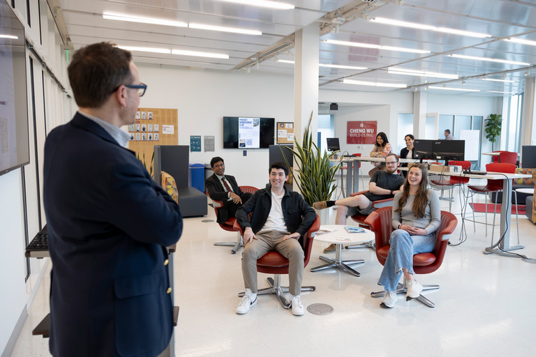 Travis Brown standing in the Shoemaker Innovation Center speaking with students.