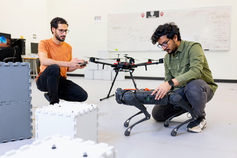 Two robotics students working on a drone