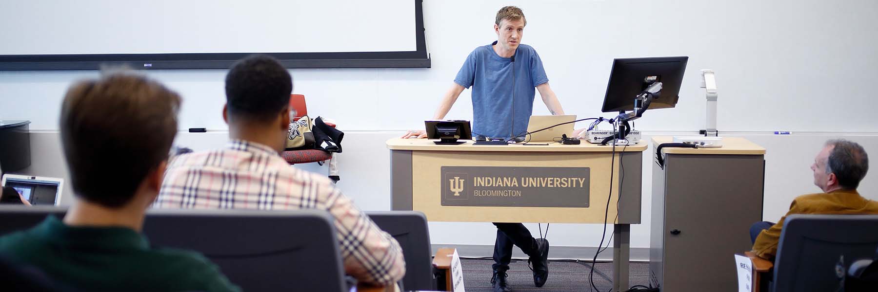 Professionals look toward IU alumnus Ian Rogers at the front of a lecture hall.
