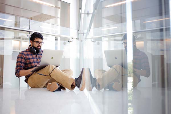 Smiling students sitting outside on a bench